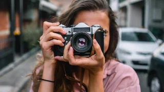 woman focusing her camera to take a picture - Best compact camera under $400