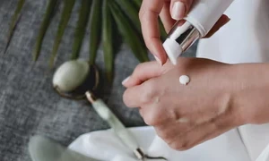 woman pumping moisturizer on her hands - Can I bring moisturizer on a plane?