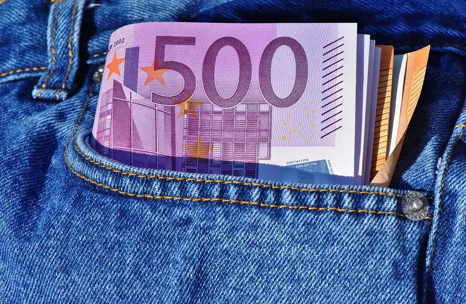 wallet and money sticking out of front pocket of jeans